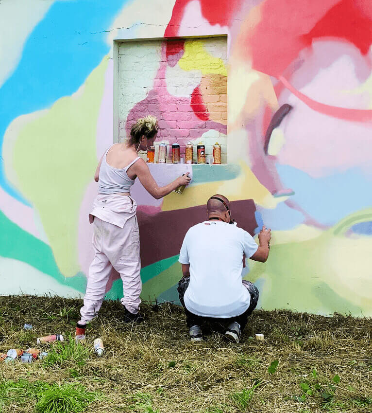 Künstlerduo Pink und Gold beim Malen eines Murals